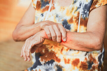 Senior woman holding his painful wrist. Concept of injury, arthritis, or carpal tunnel syndrome.