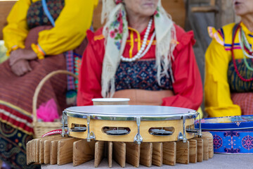 women dressed in traditional russian costume playing tambourines at a popular festival, folk music