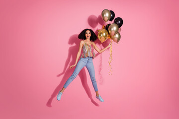 Full size photo of pretty young girl flying hold air balloons wear trendy sequins outfit isolated on pink color background