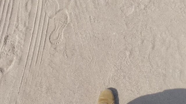 Feet of Soldier in Uniform Walking Across Sand in Desert