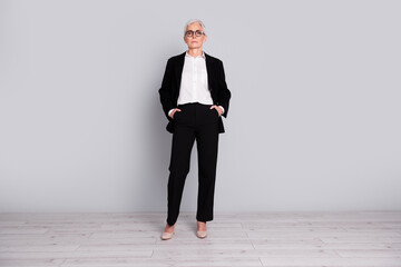 Full length photo of charming successful senior lady wear black suit isolated on grey color...