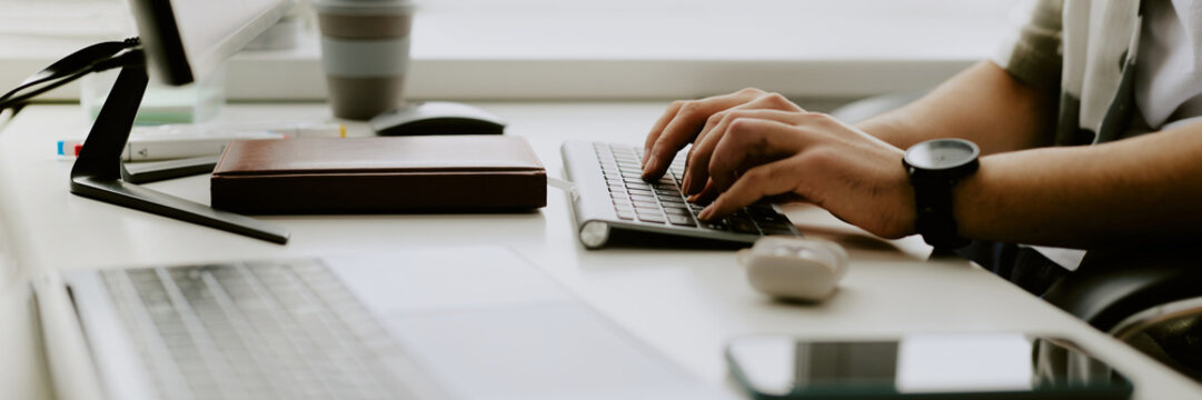 Website banner of IT company demonstrating programmers hand typing on keyboard