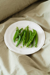 Plate of fresh green peas on the green bed