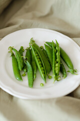 Plate of fresh green peas on the green bed