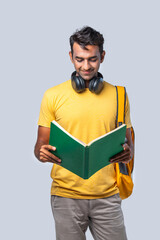 Indian asian happy young college boy with backpack, laptop and books