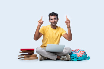 Asian Indian young college or university student studying while sitting on floor