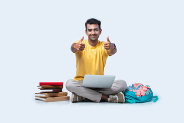 Asian Indian young college or university student studying while sitting on floor