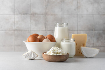 Eggs, milk, yogurt, cottage cheese, cheese side view on  light background. Dairy farm products concept