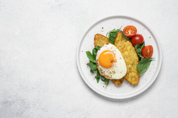 Egg, hashbrown and salad in plate on white background with copy space