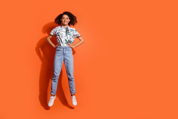 Full body length photo of american woman in jeans and summer stylish shirt posing as model with good vibes isolated on orange color background