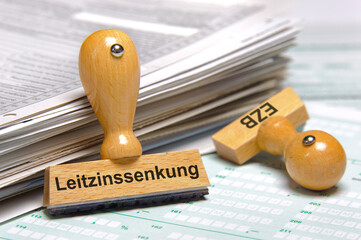 Ein Holzstempel ist beschriftet mit dem Aufdruck: Leitzinssenkung