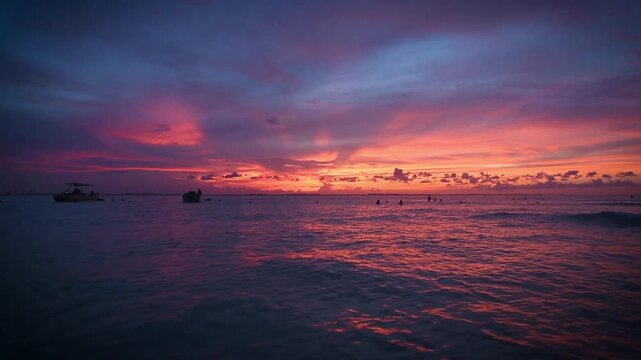 HD video of a spectacular tropical sunset over the sea of many hues and colors from the beach of Mujeres Island in Mexico