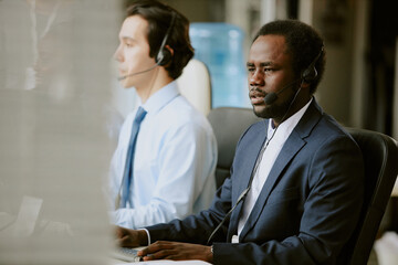 Two biracial workers of contact center having clients call during long work day