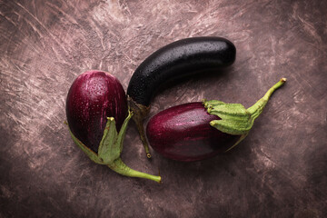 Composizione con melanzane fresche isolate su fondo scuro: natura morta ripresa dall’alto