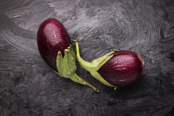 Composizione con melanzane fresche isolate su fondo scuro: natura morta ripresa dall’alto