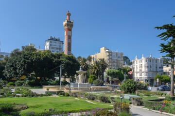 Fototapeta premium Urban Park with Tall Tower, Fountain and Lush Green Spaces.