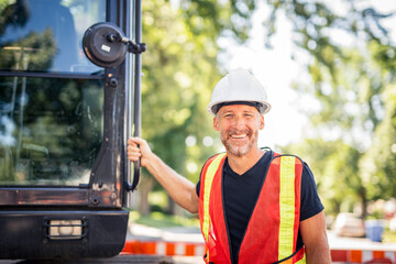 caucasian engineer with white helmet at work and having a mechanical shovel on the back © Louis-Paul Photo