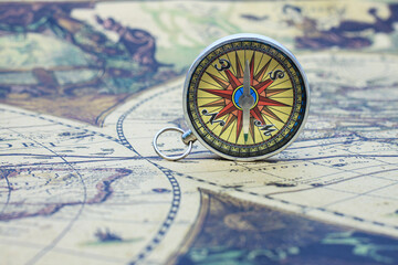 Classic round compass on background of old vintage map