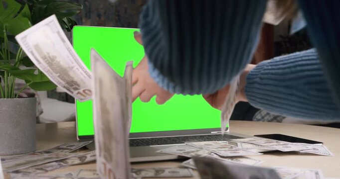 Money rain flying out of the laptop green screen. Make money online. Girl, woman catch money. Cash flow, dollar bills floating out of the laptop screen. Business making easy money online concept. 