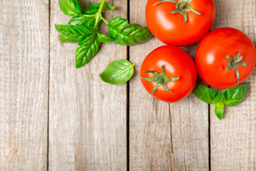 Fresh cherry tomatoes and fresh green basil on a textured background. Tomato sauce. Vegan. Ingredients for salad. Organic food. Place for text. Copy space.