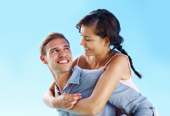 Outdoor, couple and smile with piggyback for bonding for love, freedom and support in Spain. People, relationship and blue sky for care on holiday or vacation for honeymoon, relax and break for trust