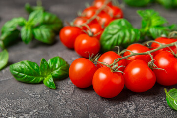 Fresh cherry tomatoes and fresh green basil on a textured background. Tomato sauce. Vegan. Ingredients for salad. Organic food. Place for text. Copy space.