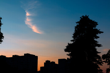 Silhouettes of houses and trees against the sky after sunset