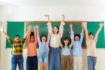 Happy teacher and students celebrating success in the classroom.