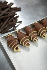 Preparing uncooked with chocolate croissants for baking bakery concept