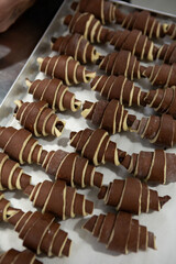 Chocolate uncooked croissants in row 
