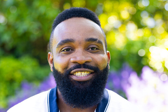 Smiling man with beard enjoying outdoor garden, looking at camera - Powered by Adobe