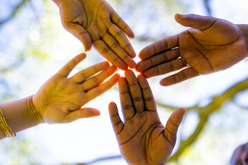 Creating circle by joining hands, friends outdoors symbolizing unity and friendship