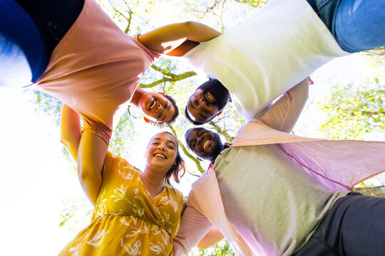 Friends standing in circle outdoors, smiling and enjoying time together