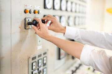 Naklejka premium Side view of hands pressing circuit board switch buttons by male and female engineers in the workshop of a large industrial power plant that produces energy for export to businesses on Earth.