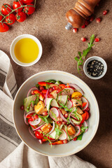 Salad with grilled salmon, fresh green  leaves, cucumber, tomatoes, pepper, radish, pomergranate and red onion . Healthy lunch salad. Top view