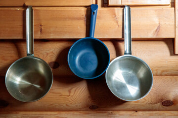 Finnish traditional wood sauna, accessory in steam room, metal and plastic ladles on a wood wall, banner with copy space