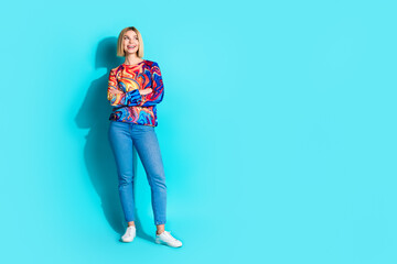 Full size photo of cheerful gorgeous girl dressed print shirt holding arms folded look empty space isolated on blue color background