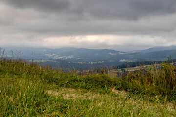 Landscape from a meadow on a slope on Ochodzita in Koniakow under a cloudy sky on a summer afternoon