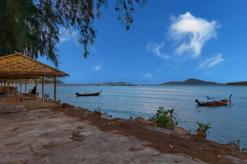Colourful Skies Sunset over Rawai Beach in Phuket island Thailand. Lovely turquoise blue waters, lush green mountains colourful skies and beautiful views of long tail Boats