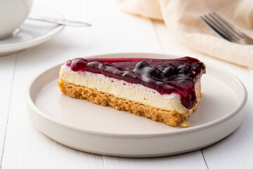 blueberry cheese pie on white plate.tasty dessert on the table with tea cup.