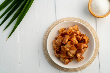 Caramelized banana roll,Crispy banana chip rolls in white plate.Fruit snack.Top view.
