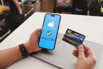 A man hands using smartphone for online shopping at cafe, Hand holding mobile phone with Payment Detail page display and credit card, online shopping concepts..