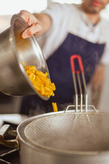 man puting pasta on boling water