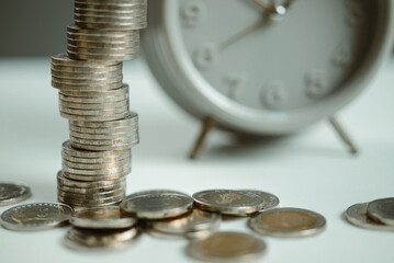 Tax season, Debt collection concept. Coin and alarm clock, white background, time to pay interest. Business tax payment overdue date. Money pension investment, old man plan, macro vintage studio photo