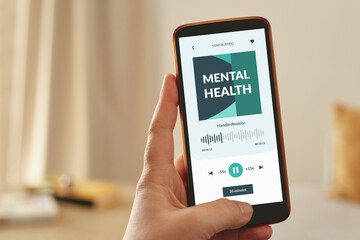 Female hand holding a mobile smartphone displaying a mental health app. Digital support concept.