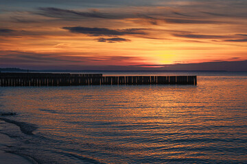 View of sand beach with wooden breakwaters on the Baltic Sea coast on sunset in Zelenogradsk. Russia