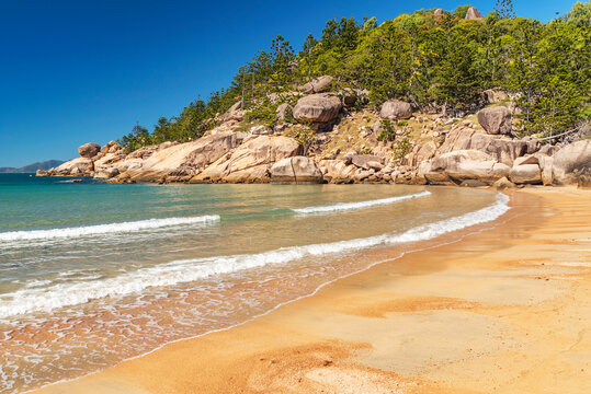 Picturesque golden sandy Alma Beach with granite boulders and turquoise water on Magnetic Island, Queensland, Australia. The island is a holiday destination 8 km offshore of Townsville.