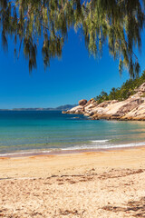 Picturesque golden sandy Alma Beach with granite boulders and turquoise water on Magnetic Island, Queensland, Australia. The island is a holiday destination 8 km offshore of Townsville.