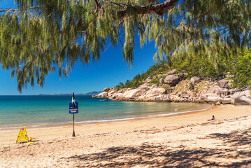 Picturesque golden sandy Alma Beach with granite boulders and turquoise water on Magnetic Island, Queensland, Australia. The island is a holiday destination 8 km offshore of Townsville.