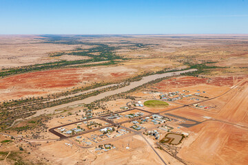 Aerial view of remote outback town Birdsville with river and desert terrain, Queensland, Australia.